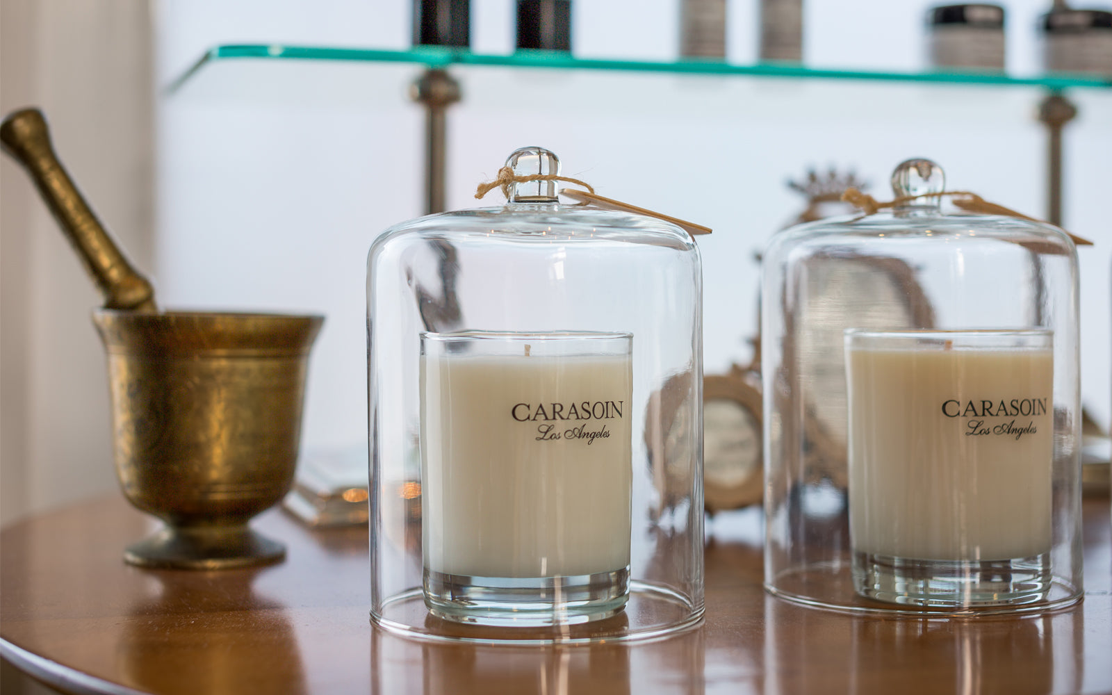 Carasoin products on a shelf, including candles and a mixing bowl